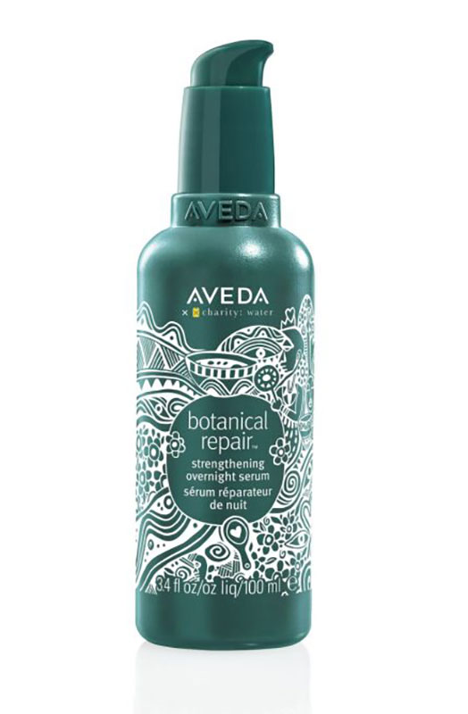A green bottle of Aveda Botanical Repair Strengthening Overnight Serum with a white floral design and pump dispenser, featuring 100 ml (3.4 fl oz) of sustainable beauty for Earth Month. - Mango Salon, VA